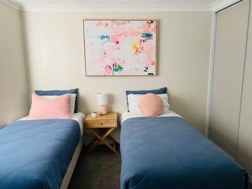 um quarto com 2 camas e uma mesa com uma fotografia em Family Favourite, Spacious 2 Bedroom Unit em Young