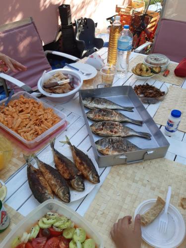 a table topped with lots of fish and other foods at Mary 's Retro Caravan in Eratini