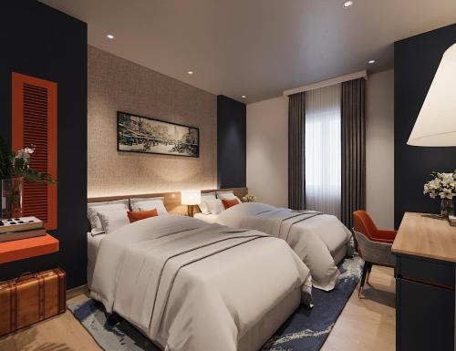ホーチミン・シティにあるNicecy NganHa Hotelのベッド2台と机があるホテルの部屋
