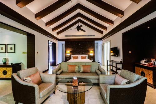a living room with a bed and a couch and chairs at Narada Resort & Spa Perfume Bay Sanya - All Villas in Lingshui