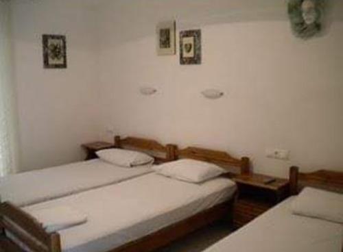 two twin beds in a room with white walls at Aris House in Paralia Katerinis