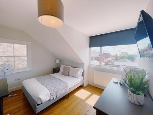 1 dormitorio con cama, escritorio y ventana en Stunning 8-Bed House with Sea & Beach Views, en Great Yarmouth