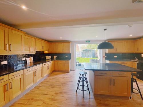 una gran cocina con armarios de madera y una gran isla en Stunning 8-Bed House with Sea & Beach Views, en Great Yarmouth