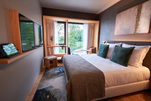 sypialnia z dużym łóżkiem i oknem w obiekcie LOISIUM Wine & Spa Hotel Champagne w mieście Mutigny