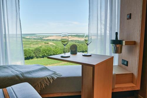 a bedroom with a table with two wine glasses on it at LOISIUM Wine & Spa Hotel Champagne in Mutigny
