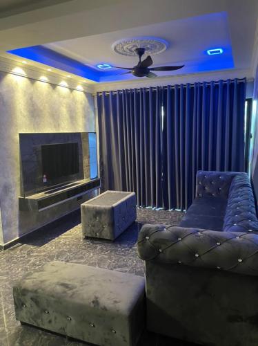 - un salon avec un canapé et une télévision dans l'établissement Sunshine Bay Resort Beachaholic Homestay, à Port Dickson