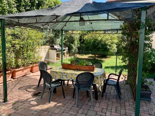 a table and four chairs under a canopy at L'angolo verde apartment in Moncalieri