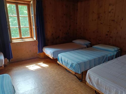 una camera con tre letti e una finestra di Guesthouse Seghetto a Valdidentro