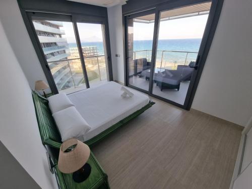 a bedroom with a bed and a balcony with the ocean at Sidi Luxury (Beach & Golf) in Alicante