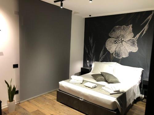um quarto com uma cama com uma pintura de flores na parede em IL TIGLIO VERDE em Foggia