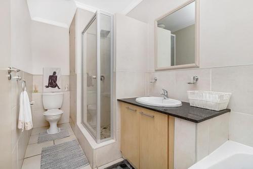a bathroom with a sink and a toilet and a shower at West Point Properties in Johannesburg