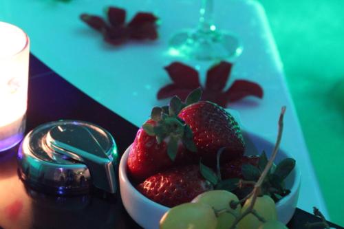a bowl of strawberries sitting on top of a table at MIŁOŚĆ ma swój adres - ZMYSŁOWE apartamenty z JACUZZI dla Dwojga in Ełk