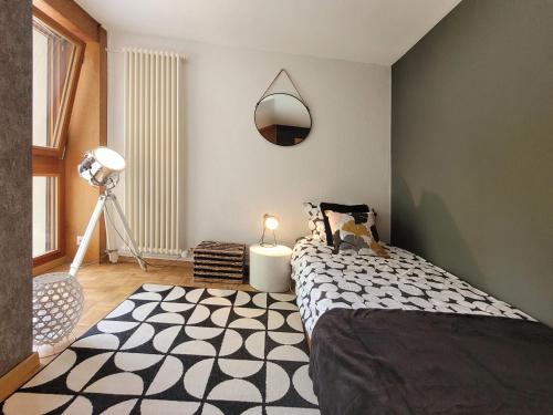 a bedroom with a bed and a mirror on the wall at L'AvantGardiste, Spacious 6 bedrooms duplex, panoramic view in Crans-Montana