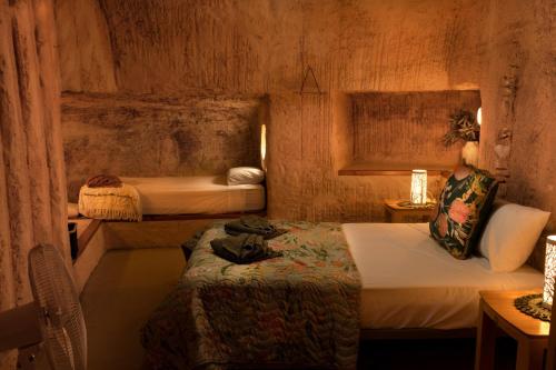 a small room with two beds and a table at Ali's Underground Home in Coober Pedy