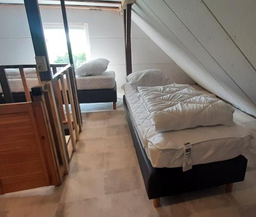 two twin beds in a room with a staircase at Monteurzimmer Ausma Wymeer Bunde - FeWo Vakantiehuis Heerenland in Bunde