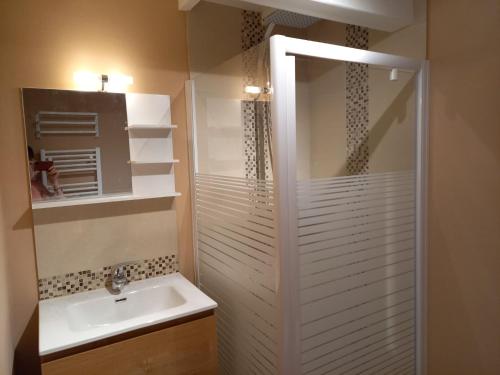 a white bathroom with a sink and a shower at Le Clos du Cerf - La Renardière in Stoumont
