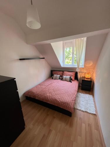 um quarto com uma cama vermelha e uma janela em Studio Loft em Pécs