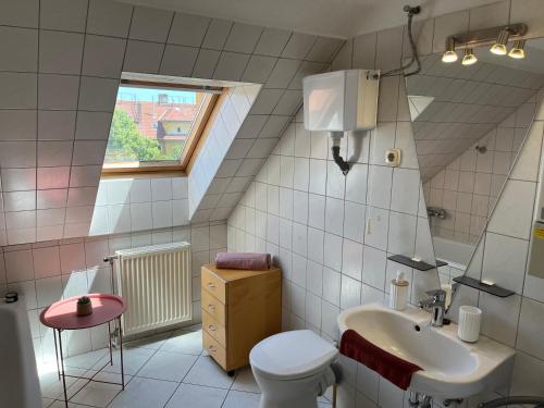 a bathroom with a sink and a toilet and a window at Studio Loft in Pécs