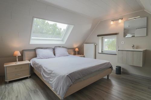 Un dormitorio con una cama grande y una ventana en Vakantiewoning Tilia, en Zottegem
