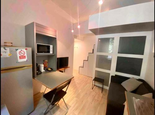 - un salon avec une table et un réfrigérateur dans l'établissement Petit studio bien placé jardin et parking gratuit, à Toulouse