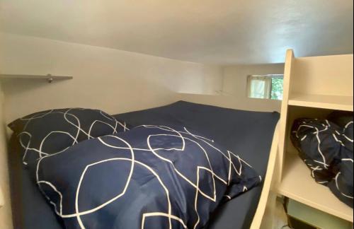 1 dormitorio con 1 cama con sábanas blancas y negras en Petit studio bien placé jardin et parking gratuit, en Toulouse
