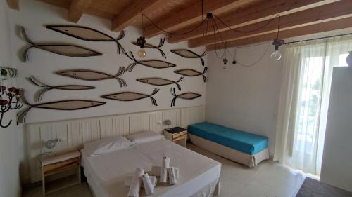 1 dormitorio con 1 cama y un mural de pescado en la pared en Le Zagare di Vendicari, en Marina di Noto