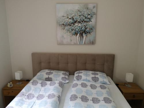 1 cama con 2 almohadas y una pintura en la pared en Apartment Gorski javor, en Jahorina