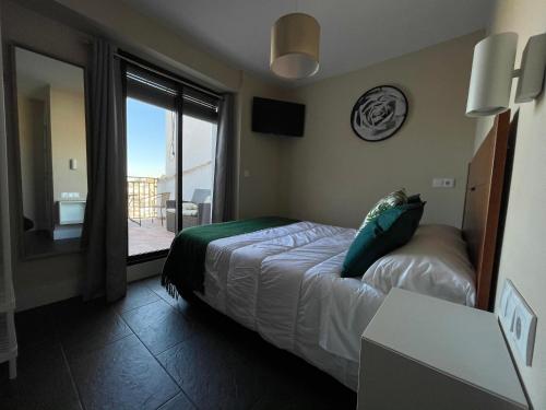 a bedroom with a bed and a view of a balcony at Casa Paseo Del Sauce in Cazorla