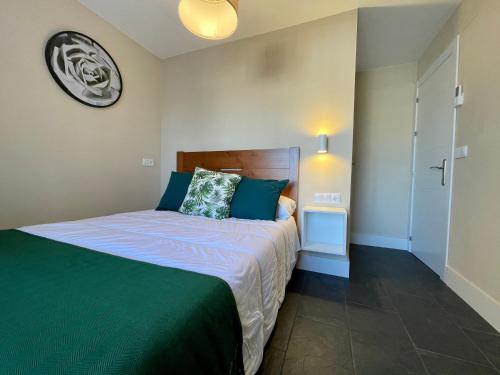 a bedroom with a bed and a clock on the wall at Casa Paseo Del Sauce in Cazorla