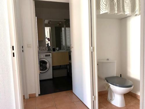 uma casa de banho com um WC e uma máquina de lavar roupa em Coeur de Fréjus, L'AMPHITHÉÂTRE, appartement 3 pièces climatisé, terrasse, barbecue, piscine & parking em Fréjus