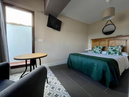 a bedroom with a bed and a table and chairs at Casa Paseo Del Sauce in Cazorla