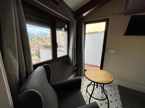 a room with a couch and a table and windows at Casa Paseo Del Sauce in Cazorla