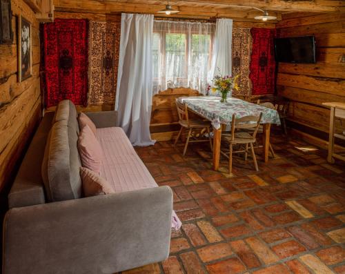 sala de estar con sofá y mesa en Alpakowo- Wolna Chata 20 en Drohiczyn