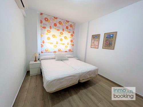 サロウにあるInmoBooking Maresto IIの白いベッドルーム(ベッド1台、窓付)