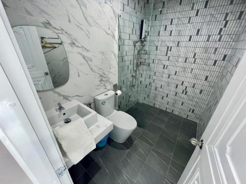 a bathroom with a toilet and a sink and a mirror at Thirty Tree Garden House in Chumphon