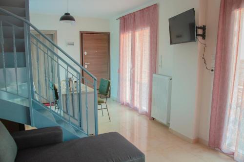 a living room with a glass staircase and a television at Garden's Sunset Αvra in Néa Michanióna