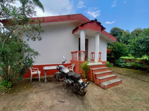 una motocicleta estacionada frente a una casa pequeña en Cabo De Rama Cottage, en Cola