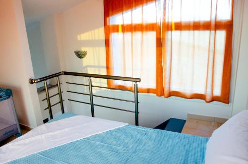 a bedroom with a bed and a window at Garden's Sunset Αvra in Néa Michanióna