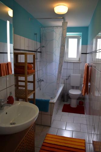 a bathroom with a tub and a toilet and a sink at Obstkorb Stralsund in Stralsund