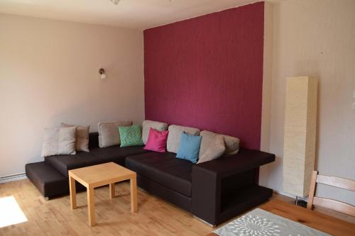 a living room with a black couch with colorful pillows at Obstkorb Stralsund in Stralsund