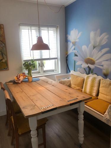 a living room with a wooden table and a couch at Appartement 4 Seasons Katwijk aan Zee in Katwijk aan Zee