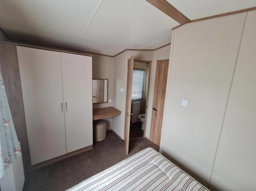 Habitación pequeña con cama y baño. en Deluxe 3 Bedroom Caravan with extra en-suite North Shore en Skegness