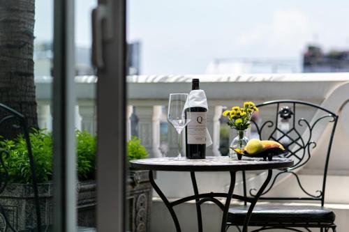a table with a bottle of wine and a glass at La Sinfonía Majesty Hotel and Spa in Hanoi