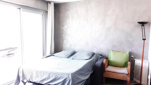 une chambre avec un lit, une chaise et une fenêtre dans l'établissement Résidence St Hélion, à Sète