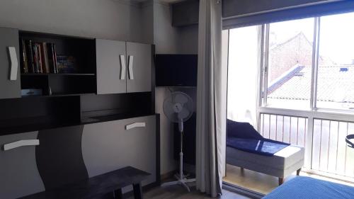 Cette chambre dispose d'un bureau, d'un ventilateur et d'une fenêtre. dans l'établissement Résidence St Hélion, à Sète