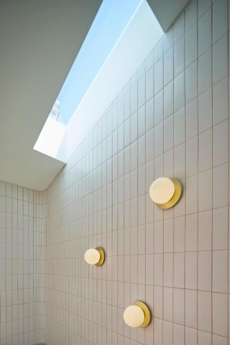 a white tiled bathroom with a skylight at Bougainvillea 33 by My Cozy Home in Faro
