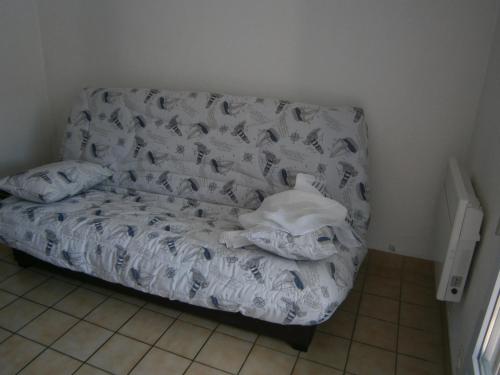 a bed sitting in a corner of a room at LES OCEANIDES in Brétignolles-sur-Mer