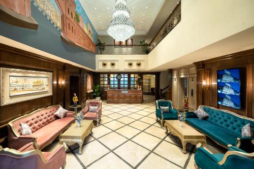 a lobby with couches and chairs and a chandelier at Country Inn Hall of Heritage, Amritsar in Amritsar