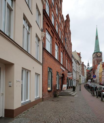 a cobblestone street in a city with buildings and a church at Apartment Klara in Lübeck