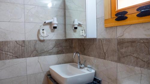 a bathroom with a white sink and a mirror at SultanMurat-Otel-Görnek Tabiat Parkı in Trabzon